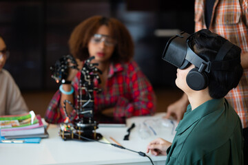 asian boy ware vr glasses and diverse teens students group building robotic hand using laptop comput