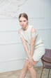 © Eno1 - A girl poses in a white knitted dress against against a white wall