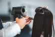 © chokniti - Asian Hairdresser giving treatment and barber occupation service, Professional hairstylist combing and using scissors cut woman's hair to young beautiful customer girl in beauty salon