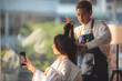 © chokniti - Asian Hairdresser giving treatment and barber occupation service, Professional hairstylist combing and using scissors cut woman's hair to young beautiful customer girl in beauty salon