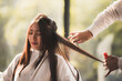 © chokniti - Asian Hairdresser giving treatment and barber occupation service, Professional hairstylist combing and using scissors cut woman's hair to young beautiful customer girl in beauty salon