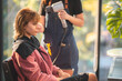 © chokniti - Asian Hairdresser giving treatment and barber occupation service, Professional hairstylist combing and using scissors cut woman's hair to young beautiful customer girl in beauty salon