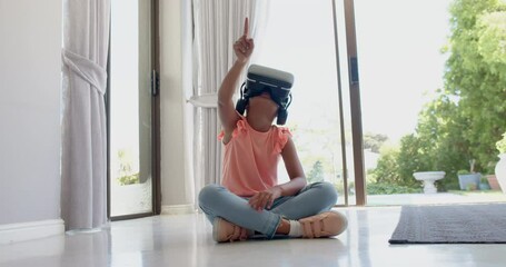 Wall Mural - happy biracial girl wearing vr headset using virtual interface at home, slow motion