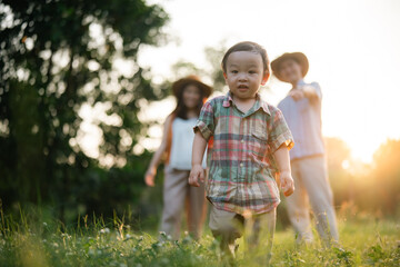 happy harmonious Asian family outdoors concept, Asian mother and son have activities happy fun together on holidays, grass land with sunlight