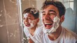 Father and son bonding and enjoying quality time in the bathroom with shaving cream on their faces.