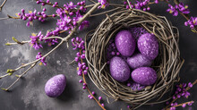 Easter Painted Purple Eggs In The Nest With Purple Spring Flowers On A Grey Background.