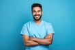 © Thanaphon - Portrait of a smiling happy male medical doctor or nurse standing isolate on blue background, Medical concept.