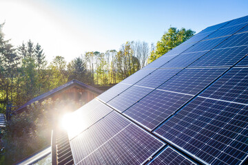 Solar panels and sunlight reflextions on the roof against blue sky background. Concept clean power energy.