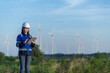 © reewungjunerr - Two engineers working and holding the report at wind turbine farm Power Generator Station on mountain,Thailand people,Technician man and woman discuss about work