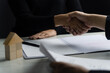 © arneaw - Shake hand Real estate brokerage agent Deliver a sample of a model house to the customer, mortgage loan agreement Making lease and buy and sell house And contract home insurance mortgage loan concept