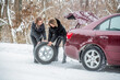 © Yevhen - Girls trying to repair the car, engine repair, tire change. Female using changing wheel. Womans changing the punctured tyre on his car in winter. Pretty girl replacing tyres. Fault car in the winter
