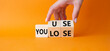 You use or lose symbol. Businessman hand Turns cube and changes word You lose to You use. Beautiful orange background. Business and You use or lose concept. Copy space