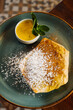 Delicious pancake with sugar powder and seasoning with sauce on plate