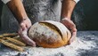 the male hands in flour and rustic organic loaf of bread
