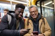 © Jorge Ferreiro - black man and a caucasian man looking at their mobile phones together