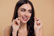 © anatoliycherkas - Beautiful Female Using Dental Floss And Smiling At Camera