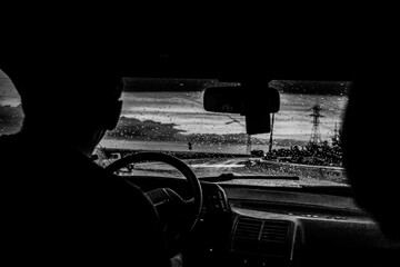 Wall Mural - view from a car on the highway in bad weather conditions, rain and fog, at a beautiful red sunset