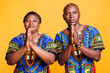 African american man and woman pair begging and asking for help while standing with palms folded portrait. Couple praying to god and pleading for blessing while looking at camera