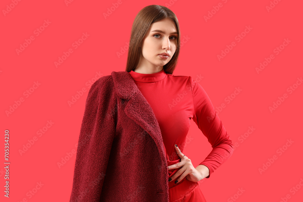 Pretty stylish young woman on red background