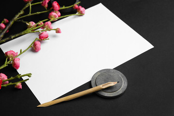 Wall Mural - Composition with blank sheet of paper, nib pen and blooming branch on dark background, closeup. International Haiku Poetry Day