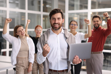 Sticker - Portrait of happy businessman with laptop and his team in office