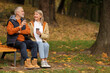 © New Africa - Affectionate senior couple with cups of coffee on wooden bench in autumn park, space for text