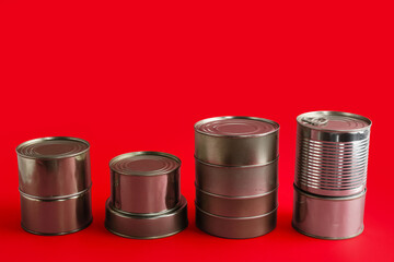 Wall Mural - Stacks of tin cans with fish on red background