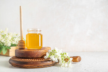 Wall Mural - Jar of honey with flowers of acacia and dipper on light background