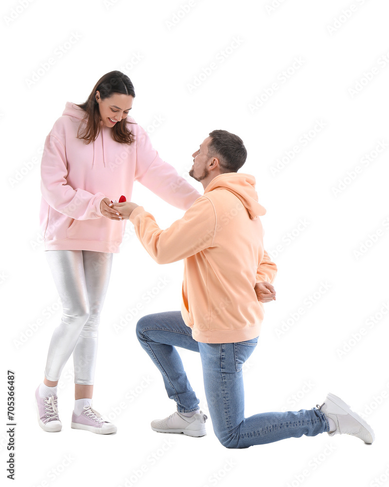 Young man proposing to his girlfriend on white background