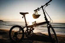 A Folding Bike On Sunrise Seaside Rocks