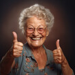 © Alexandr Modelni - Joyful Senior Woman Expressing Positivity: Elderly Lady with a Wide, Genuine Smile on a Monochromatic Background, Radiating Positivity, and Gesturing Thumbs Up. Positive Emotions and Like Gesture Conc