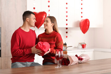 Sticker - Beautiful young couple with bouquet of roses, gift box and wine glasses celebrating Valentine's Day at home