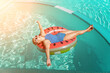 © svetograph - Happy woman in a swimsuit and sunglasses floating on an inflatable ring in the form of a watermelon, in the pool during summer holidays and vacations. Summer concept.