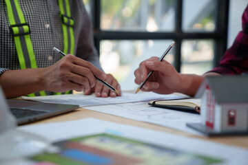 Wall Mural - Construction concept and teamwork meeting structure The engineer or architect for the project works with partners and engineering tools to create workplace models and blueprints.