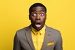 Young man Africa dressed in suit is shocked, solid background