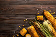 Grilled corn on the cob on kitchen wooden table flat lay background with copyspace