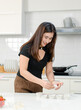© Bangkok Click Studio - Asian professional female pastry bakery baker chef housewife standing using decorating topping preparing cupcakes in full decorated white kitchen