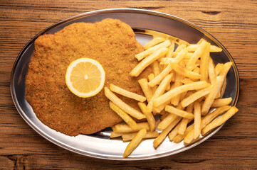 Overhead view of a plate of Milanese with French fries