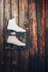 pair white skates hanging wooden