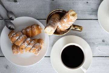 tubes with cream and coffee. on a wooden background. dessert