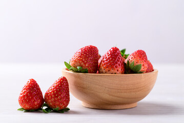 Wall Mural - Fresh strawberry fruit in wooden bowl on white background