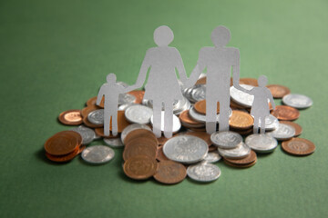 Wall Mural - Paper family with a coins on the green background.