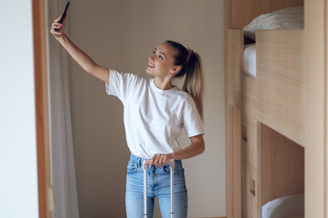 Wall Mural - Cute trendy young girl with a suitcase