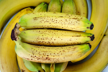 Wall Mural - Top view of a bunch of green bananas. Banana skin has dark spots. The flesh of the fruit is soft, sweet. Nutrition and healthful. Taiwan food and agriculture concept.