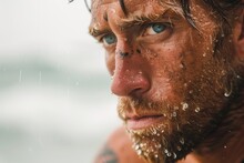 A Rugged Man With Weathered Skin And A Bushy Beard Stares Out Into The Vast Wilderness, The Glistening Water Droplets On His Face A Testament To His Strength And Resilience