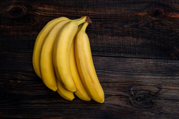 Wall Mural - Some bananas on white wooden table. Empty copy space for editor's text.