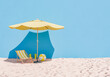 © Antonio Solano - 3D rendering of a relaxing beach setup with a yellow umbrella, a striped lounge chair, and a beach ball on sand against a blue wall background, concept of summer leisure.