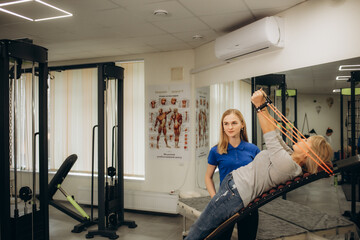 The healthy heart is a youthful heart. Shot of a senior woman using weights with the help of a physical therapist.