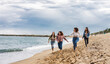 © PintoArt - open shot of diverse ethnic friends running free empowered on the beach