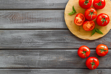 Wall Mural - Cooking background with tomatoes and basil on wooden board